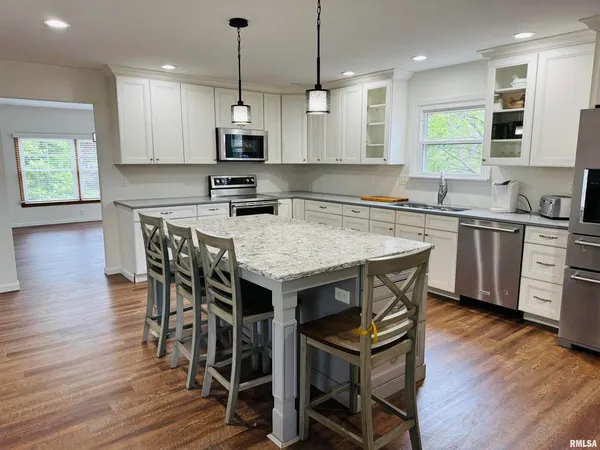a kitchen with stainless steel appliances granite countertop a kitchen island hardwood floor sink stove and wooden floor