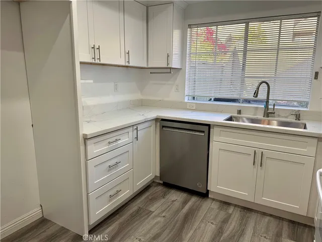 a view of a kitchen with wooden floor and electronic appliances
