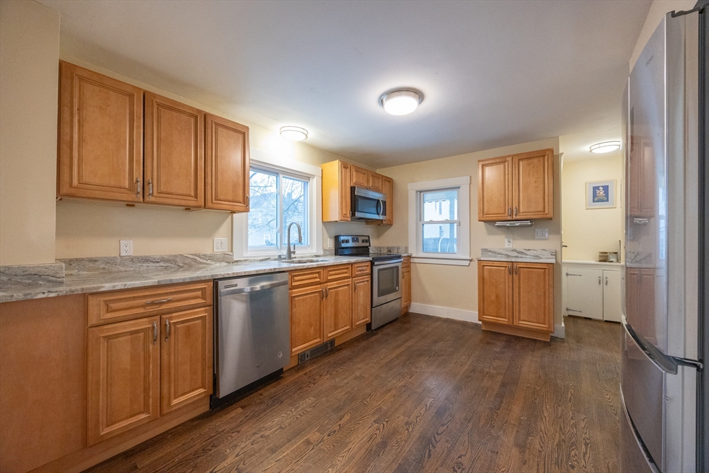 21 Manning Street Salem, MA 01970 - Photo 12 of 26 a kitchen with granite countertop wooden floors stainless steel appliances and sink