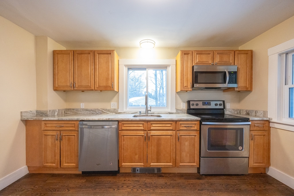 21 Manning Street Salem, MA 01970 - Photo 10 of 26 a kitchen with stainless steel appliances granite countertop a stove top oven a sink and a microwave