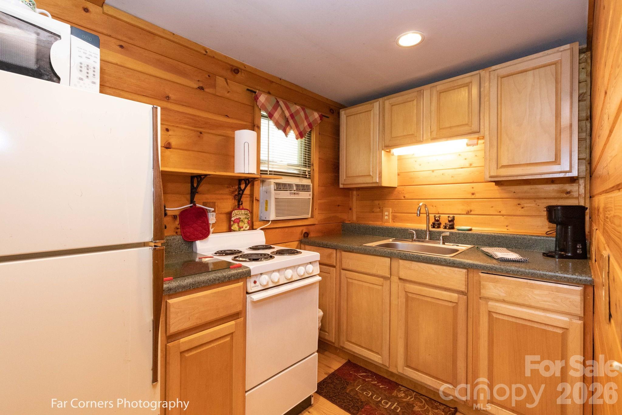 2670 Dicks Creek Road Whittier, NC 28789 - Photo 16 of 21 a kitchen with stainless steel appliances granite countertop a sink stove and refrigerator