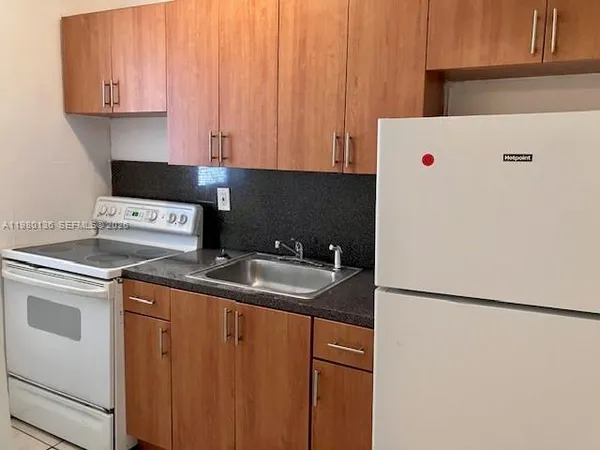 a kitchen with a sink and a refrigerator