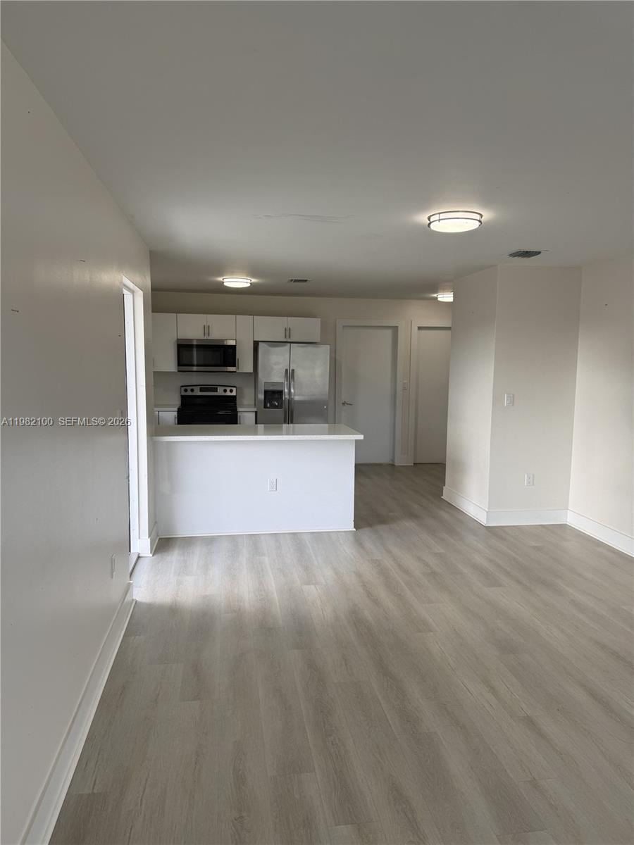 10384 Southwest 173rd Street, Unit 2 Miami, FL 33157 - Photo 2 of 12 a view of empty room with wooden floor