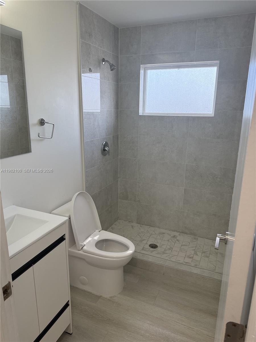 10384 Southwest 173rd Street, Unit 2 Miami, FL 33157 - Photo 5 of 12 a white toilet sitting next to a bathroom sink