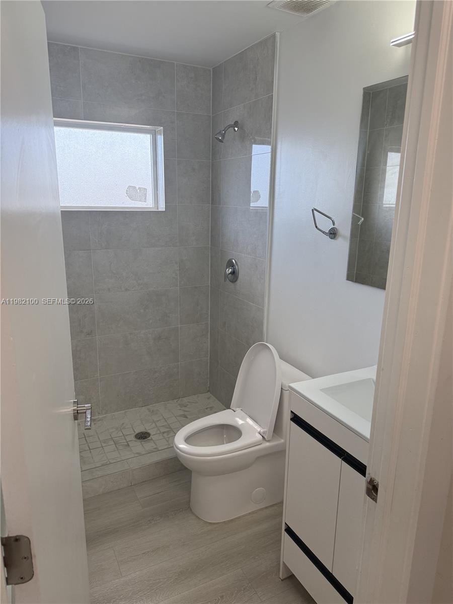 10384 Southwest 173rd Street, Unit 2 Miami, FL 33157 - Photo 7 of 12 a white toilet sitting next to a bathroom sink