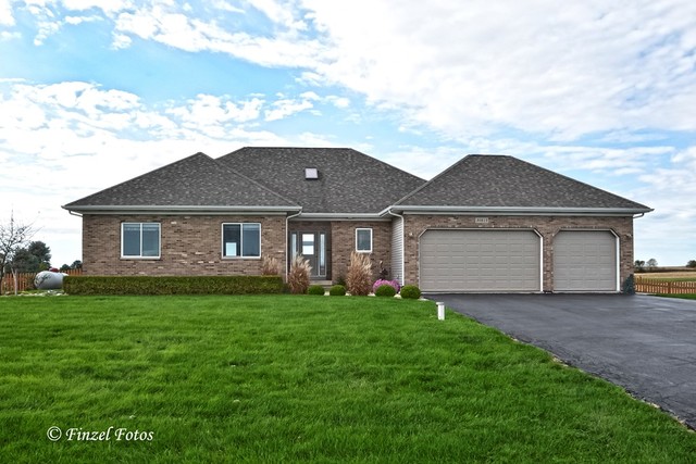 30813 Lincoln Road Genoa, IL 60135 - Photo 1 of 20 a front view of a house with a yard and garage