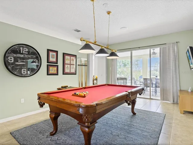 a room with pool table and windows
