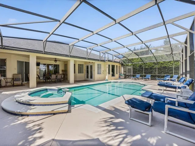 a patio with a table and chairs and potted plants