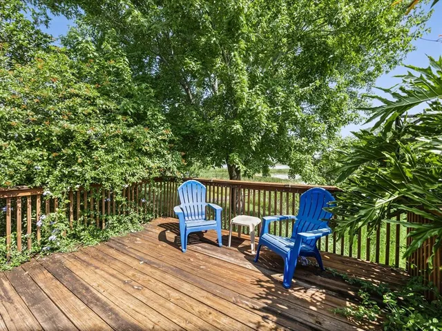 a view of a chair and table on the wooden deck