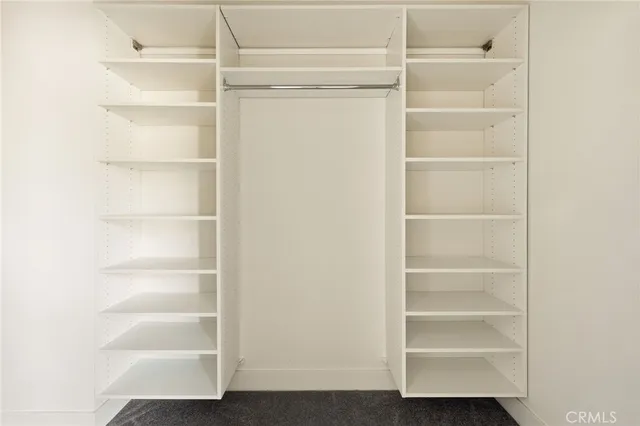 a view of walk in closet with empty racks
