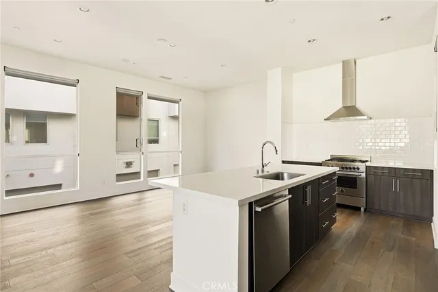a kitchen with stainless steel appliances granite countertop a sink stove and wooden floor