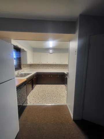 a kitchen with a sink and a refrigerator