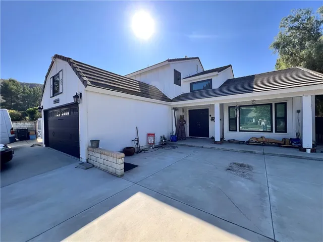 a view of a house with backyard and sitting area