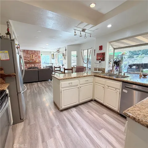 a living room with furniture a large window and wooden floor