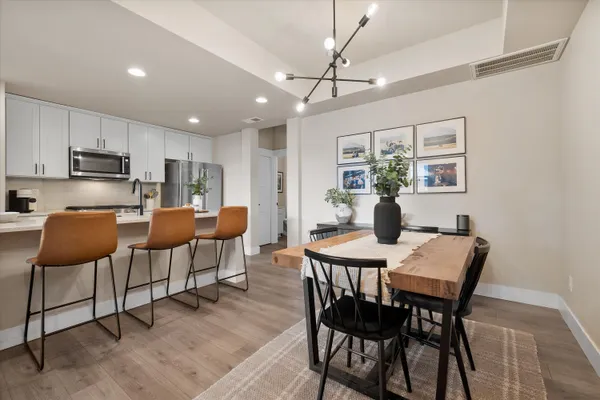 a view of a dining room with furniture a rug and wooden floor