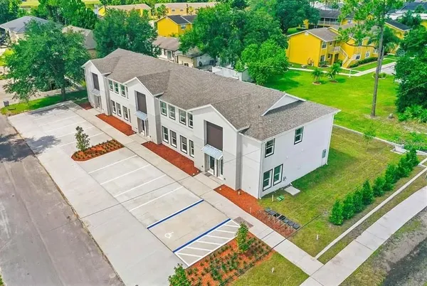 an aerial view of residential houses with yard and trees