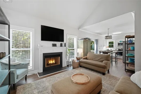 a living room with furniture a flat screen tv and a fireplace