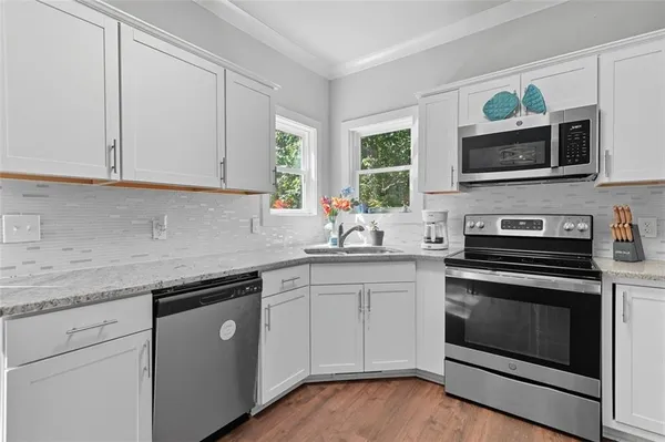 a kitchen with stainless steel appliances granite countertop a stove microwave and sink
