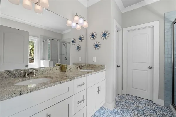 a bathroom with a granite countertop sink a mirror and a shower