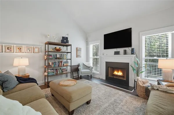 a living room with furniture a fireplace and a flat screen tv