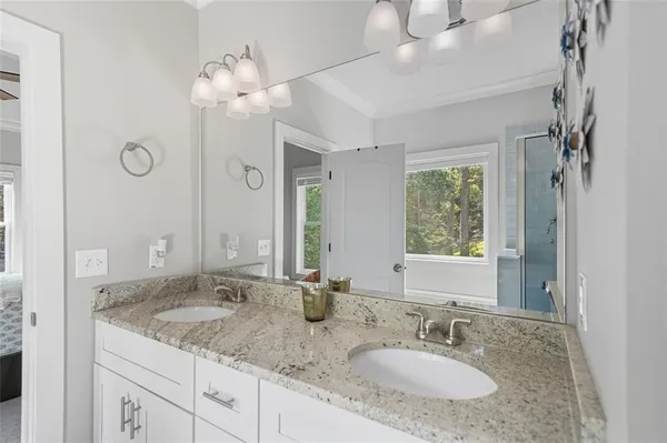 a bathroom with a granite countertop sink a mirror and a shower