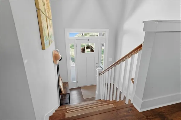 a view of staircase with railing and white walls