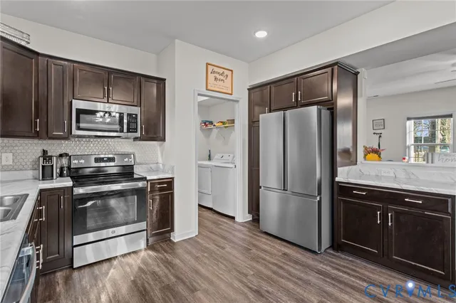a kitchen with stainless steel appliances granite countertop a refrigerator stove and sink