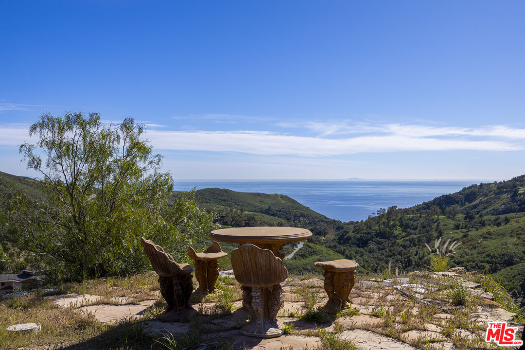 3030 Encinal Canyon Road Malibu, CA 90265 - Photo 9 of 12 a view of a terrace with a table and chairs under an umbrella