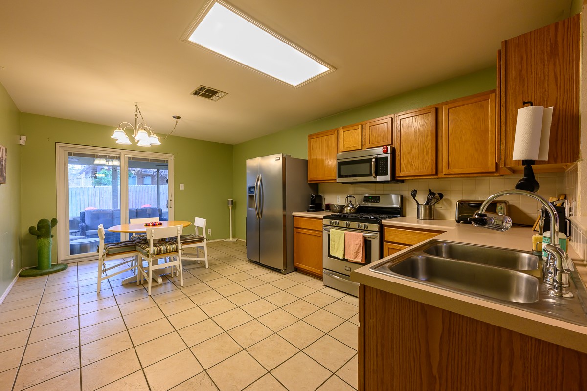 8920 Frock Court Austin, TX 78748 - Photo 4 of 22 a kitchen with a sink a counter top space appliances and cabinets
