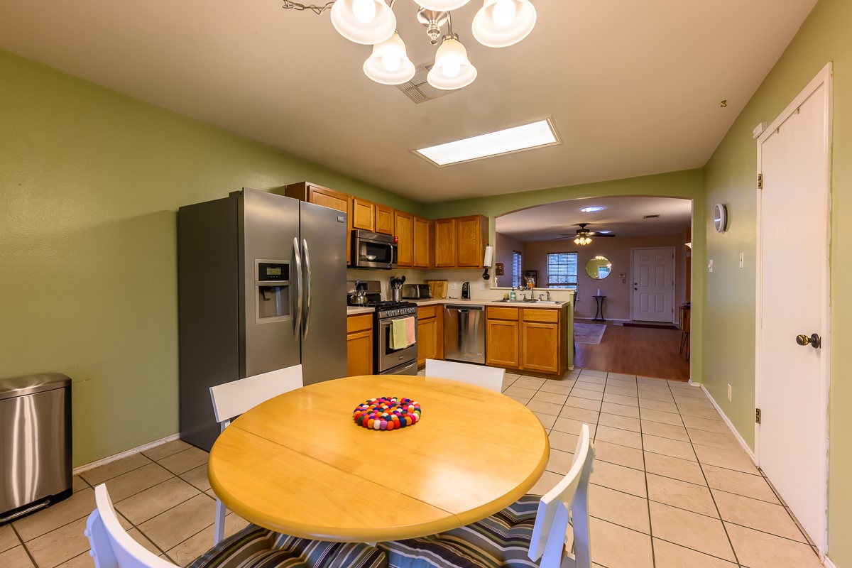 8920 Frock Court Austin, TX 78748 - Photo 6 of 22 a kitchen with stainless steel appliances wooden floor dining table and chairs