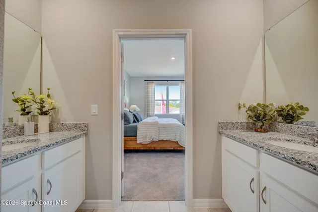 a en suite bathroom with a granite countertop sink and a mirror