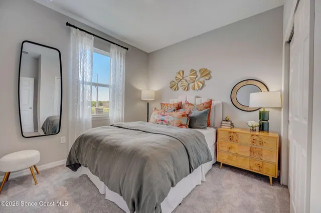 a bedroom with bed and a mirror on dresser