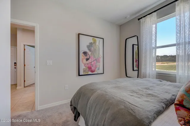 a bedroom with a bed and a painting on the wall