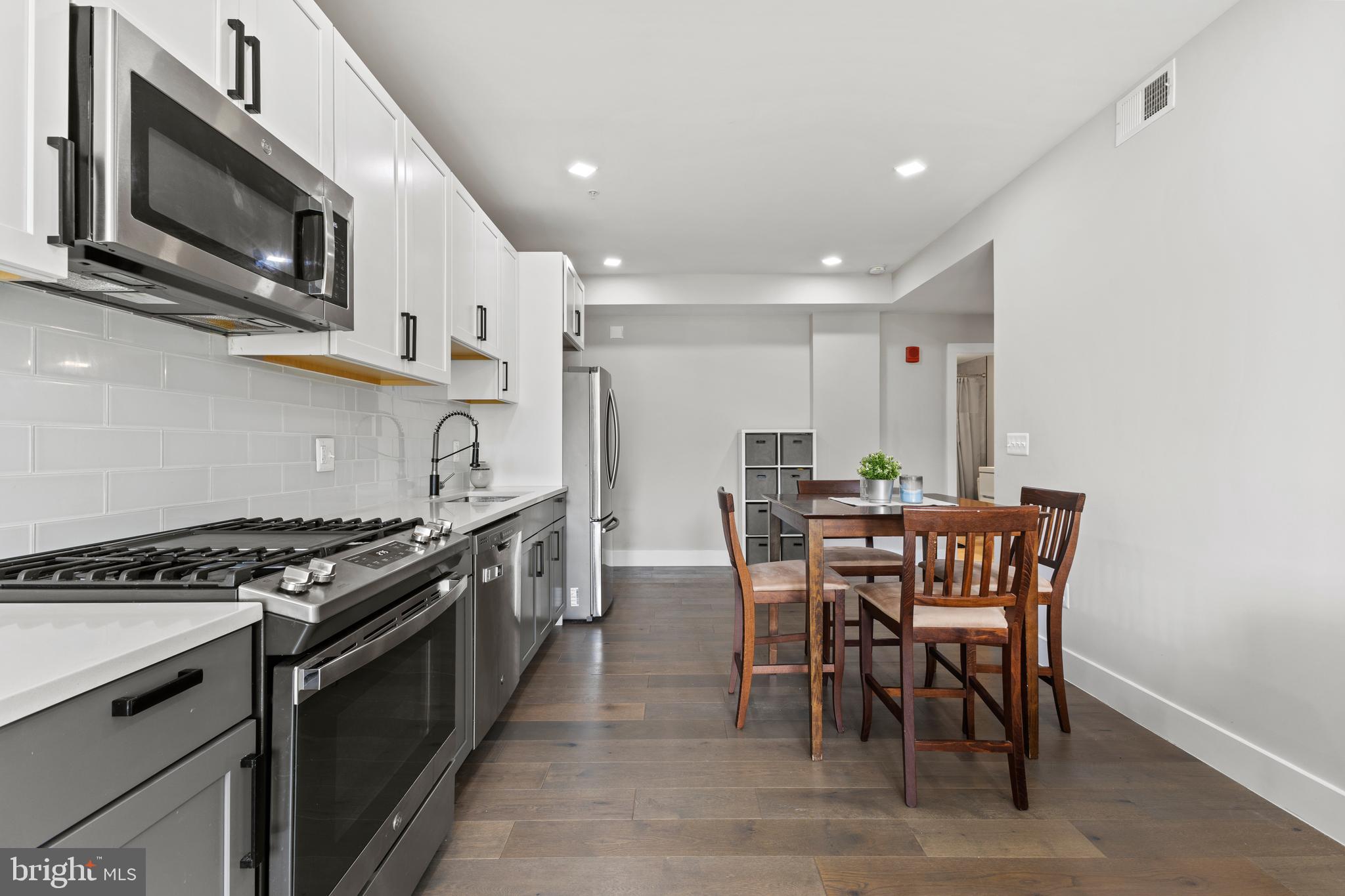 1028 Bladensburg Road Northeast, Unit 37 Washington, DC 20002 - Photo 4 of 29 a kitchen with stainless steel appliances a stove a table and chairs