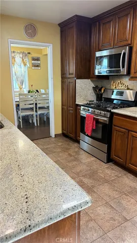 a kitchen with stainless steel appliances granite countertop a stove microwave and refrigerator