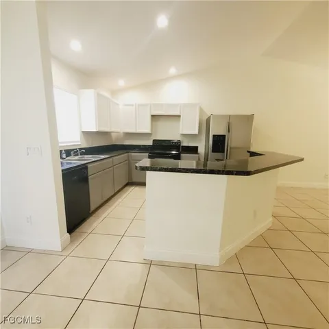 a kitchen with granite countertop white cabinets and white appliances