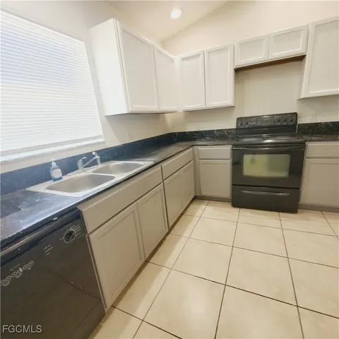 a kitchen with stainless steel appliances granite countertop a sink and a refrigerator