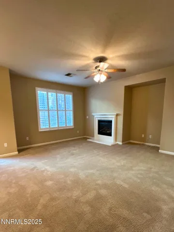 a view of an empty room with a fireplace and a window