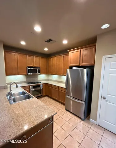 a kitchen with granite countertop a refrigerator and a sink