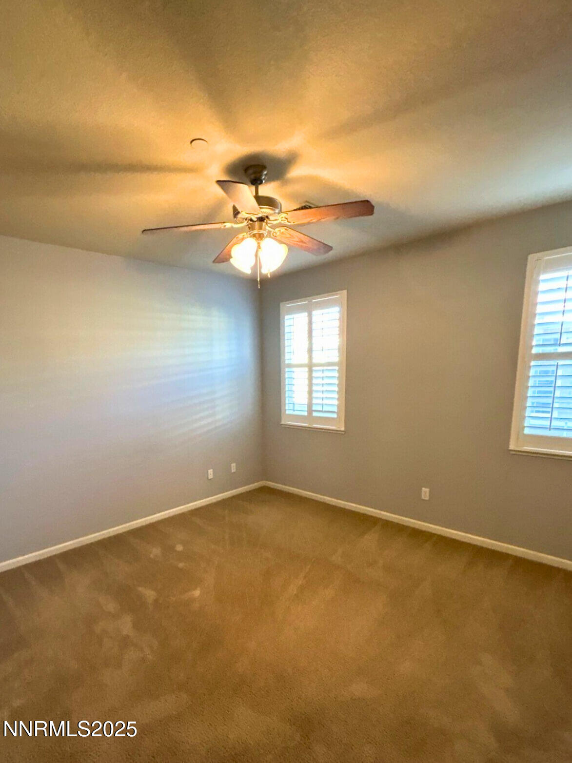 1828 Wind Ranch Road, Unit B Reno, NV 89521 - Photo 10 of 19 an empty room with a chandelier fan and windows