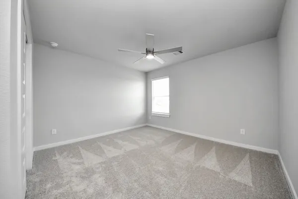 an empty room with a window and a fan