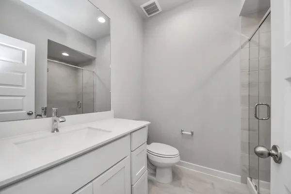 a bathroom with a sink a toilet and shower