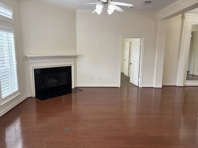 wooden floor fireplace and windows in an empty room