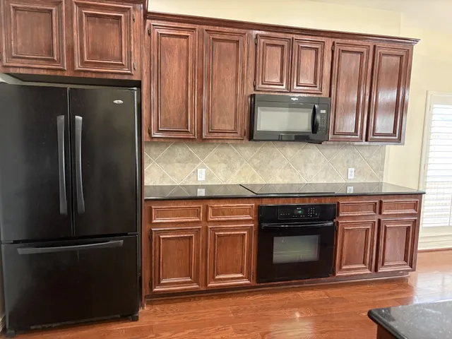 a kitchen with granite countertop stainless steel appliances and wooden cabinets
