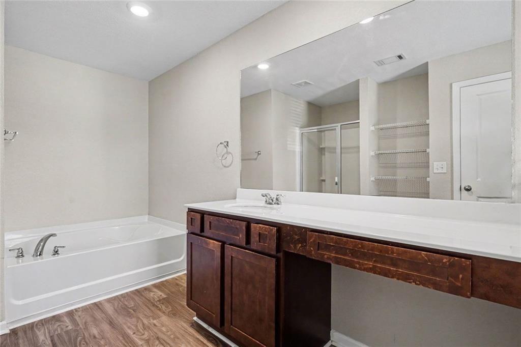 10941 Wheeler Trace Hampton, GA 30228 - Photo 19 of 21 a bathroom with a tub sink and mirror