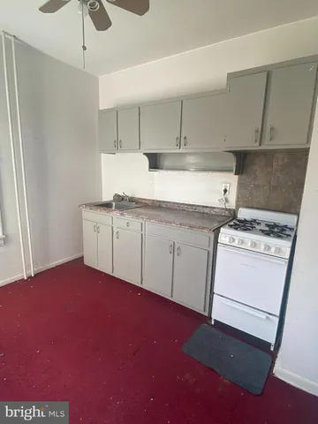 a kitchen with a sink stove and white cabinets