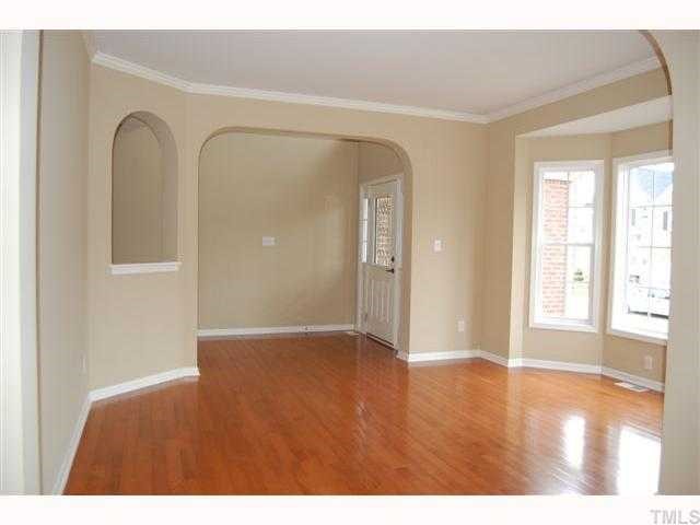 8620 Churchdown Court Raleigh, NC 27613 - Photo 4 of 12 a view of an empty room with wooden floor and a window