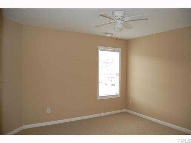 8620 Churchdown Court Raleigh, NC 27613 - Photo 9 of 12 an empty room with a window and a ceiling fan