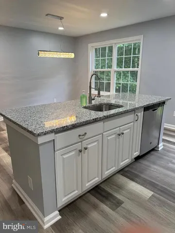 a kitchen with granite countertop white cabinets and a large window