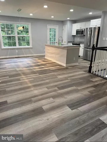 a view of kitchen with kitchen island sink microwave and refrigerator